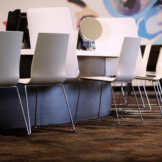 Empty styling chairs and mirrors along the counter of a modern hair salon